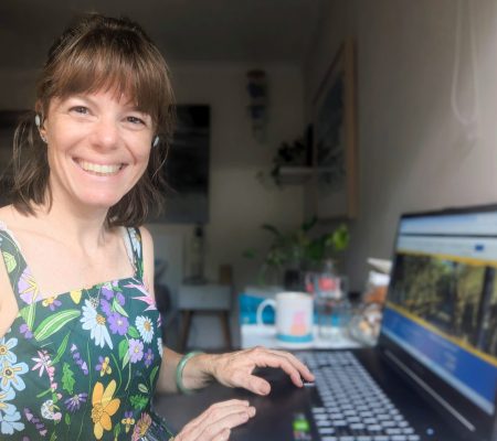 Heather smiling while writing at her computer