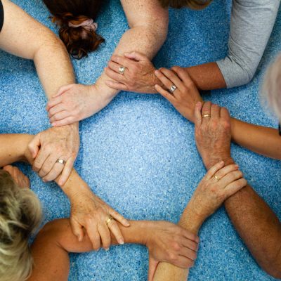 Yoga students forming a supportive circle with their hands