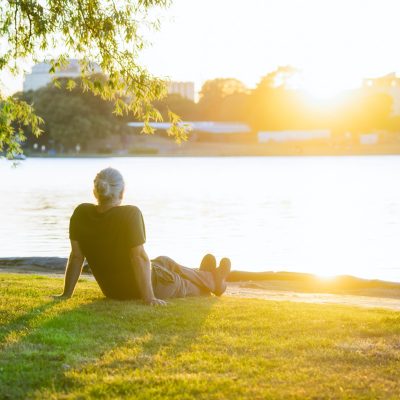 A person resting beside the river in warm afternoon light