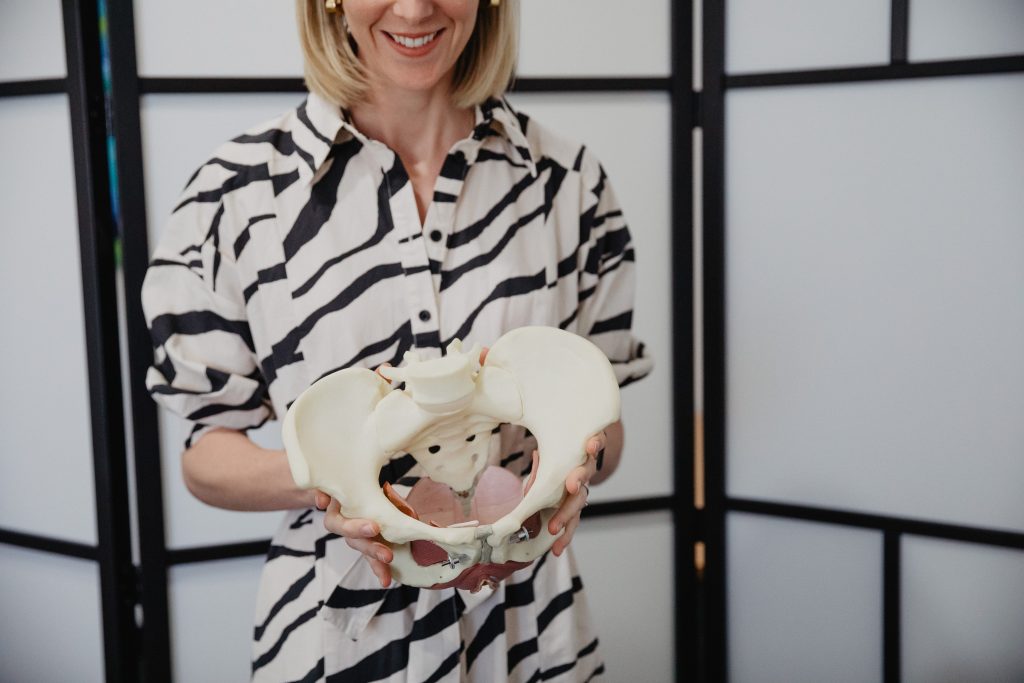 Pelvic physiotherapist Louise Hug holding an anatomical pelvis model