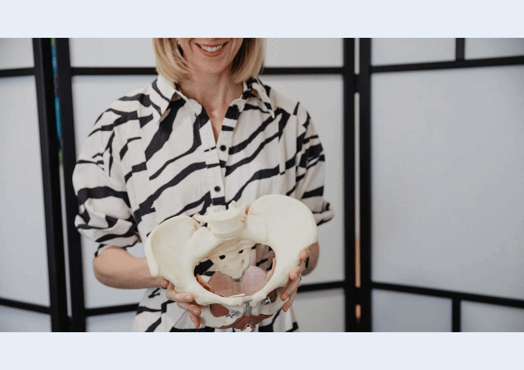 Pelvic Physiotherapist Louise Hug holding an anatomical pelvis model